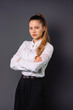 © Viorel - Young blonde businesswoman crossed her arms and posing on a gray background.