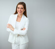 Business woman in white business suit standing with crossed arms.
