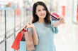 © Timeimage - Young girl standing holding a credit card in the shopping mall