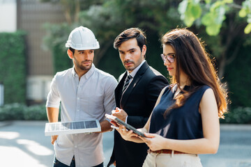 Wall Mural - Young Executive CEO business man and woman secretary meeting with energy engineer plan a project to build a solar panel for the building under construction.