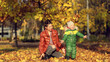 © yavdat - Mom and son throw autumn leaves in autumn park, family fun. family enjoying a walk in nature. happy motherhood concept.