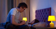 © TommyStockProject - Side view of dad putting child to bed and talking before sleep