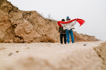 Wall Mural - Attractive young multiethnic couple walking at the beachside