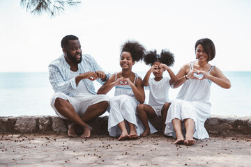 Happy African American family, Father, Mother, Two daughter enjoying and funning together in outdoor park seaside. Vacation relax time concept.