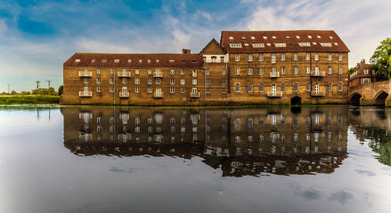 Wall Mural - A view across the River Great Ouse at Riverside, Godmanchester, UK  towards the old Mill buildings in springtime