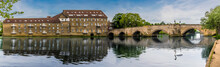 A Panorama View Of The Mill And Old Bridge At Riverside, Godmanchester Reflected In The Calm Waters Of The River Great Ouse In Springtime