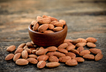 Canvas Print - Almonds in wooden bowl on table.