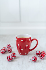 Sticker - Selective focus shot of a cup of delicious hot coffee surrounded with red little Christmas balls