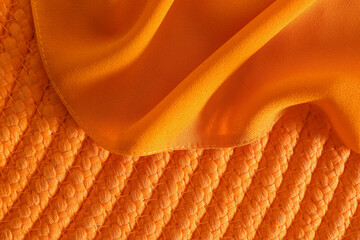 Orange fabric on wicker mat, top view