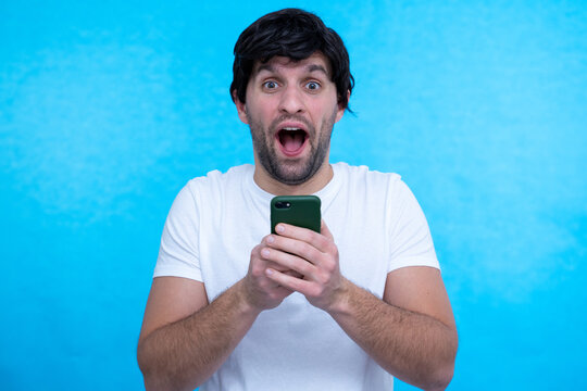 Photo of positive cheerful handsome man smiling excited about positive news isolated blue color background