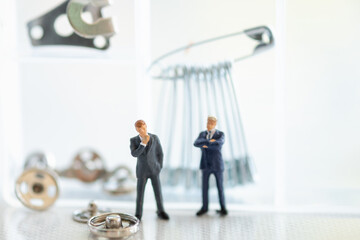 Miniature 2 businessmen stand behind the repair kit, cloth mats