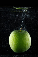 Fresh green apple splashing in water