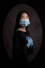 Modern Renaissance Portrait: Asian Girl In Black Dress Wearing A Blue Mask And Gloves In Times Of Covid Pandemic