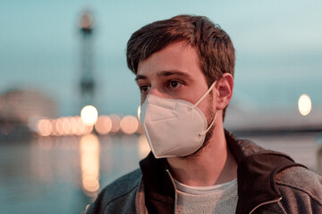 COVID-19 Pandemic coronavirus Young man next to the port wearing face mask protective for spreading of disease virus SARS-CoV-2