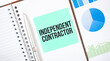 Green card on the white notepad. Text independent contractor. Business concept