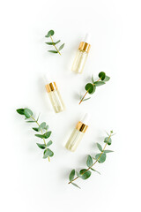 Wall Mural - Eucalyptus essential oil, eucalyptus leaves on white background. Natural, Organic cosmetics products. Medicinal plant. Natural Serums. Flat lay, top view.