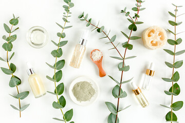 Wall Mural - Eucalyptus essential oil, eucalyptus leaves on white background. Natural, Organic cosmetics products. Medicinal plant. Natural Serums. Flat lay, top view.