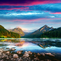 Wall Mural - Peaceful summer view on Obersee lake in Swiss Alps. Sunrise sky and mountains reflections in clear water. Nafels village, Switzerland. Landscape photography