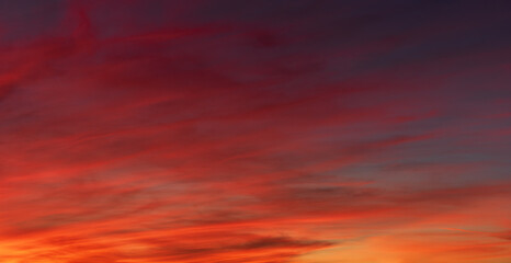 Wall Mural - Red orange clouds in the sky at dusk background.