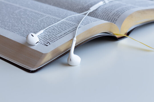 open bible with headphones or earbuds