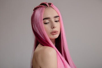 Fashion woman with pink hair. Portrait on a gray background. copycpase