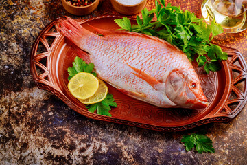 Wall Mural - Whole fresh tilapia with spices and lemon.