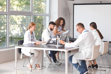 Wall Mural - Team of doctors during meeting in modern clinic