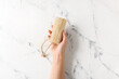 Female hand with loofah on light background