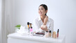 Smiling Woman Applying Make-up By Beauty Products On Table