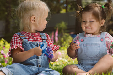 Wall Mural - Two little girls sisters paint with finger paints