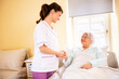 © didesign - Nursing home doctor holding a hand of a senior woman patient occupant while she is lying