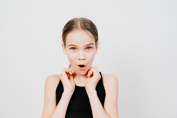 A teenage girl in a black T-shirt is surprised and her hands are at the face. white background. big discounts in stores. Surprise. copy space 