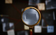 © New Africa - Looking at detective board through magnifying glass, closeup
