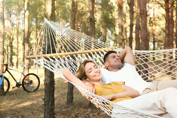 Wall Mural - Happy couple resting in hammock outdoors on summer day