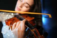 Beautiful Young Woman Playing Violin In Dark Room, Closeup