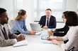 © chagin - Group of business people sitting around the office desk and discussing the project