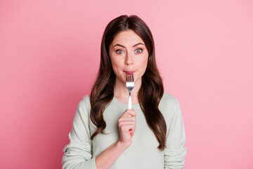 Sticker - Portrait of adorable curly hairstyle lady biting lick fork smile isolated on pastel pink color background