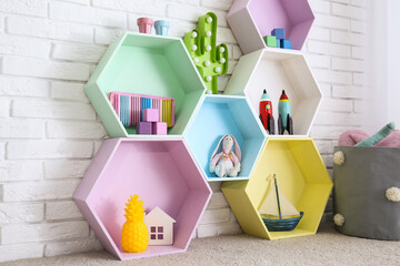 Sticker - Colorful shelves near brick wall in child room interior