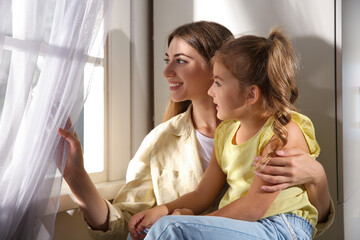 Poster - Young woman and her daughter near window at home