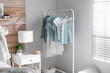 Rack with stylish women's clothes in modern room. Interior design