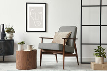 Stylish Scandinavian Composition Of Living Room With Design Armchair, Black Mock Up Poster Frame, Commode, Wooden Stool, Book, Decoration, Loft Wall And Personal Accessories In Modern Home Decor.