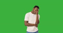 Depressed African American Man Crying Over Green Background
