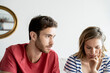 © PhotoAlto - Thoughtful young couple sitting in house