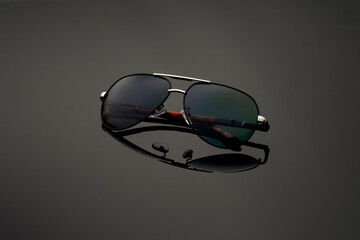 black sunglasses in aviator frame on mirror background. Glasses summer collection