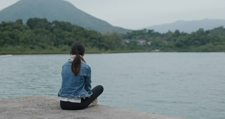 Wall Mural - Woman sit on pier dock and enjoy the sea view