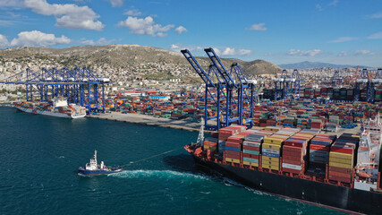 Aerial drone photo of container truck size cargo vessel approaching international container loading - unloading logistics terminal of Piraeus, Perama, Attica Greece