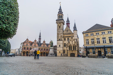 Overview of the makretplace in Aalst, east flanders, Belgium.  Great view on a bright day with almost no people on the marketplace.  Authentic belford with statue and 2 people walking hand in hand.  