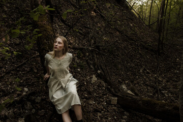 Portrait of a beautiful mysterious woman with blond hair in the forest.  like a fairytale. Warm tone