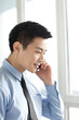 © eastfenceimage - Portrait of young businessman talking on cell phone in office
