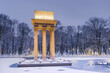 © marcin jucha - Illuminated General Bem Monument in Tarnow, Poland. Magical Winter Snowfall in City Park and Pond at Twilight